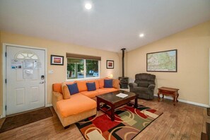 Un salon comprenant un canapé, un fauteuil, une table basse et une cheminée.