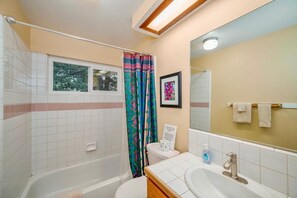 Un baño con bañera, inodoro y lavabo.