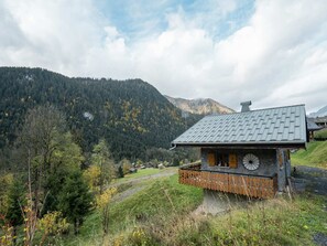A rustic mountain cabin with a stone foundation, wooden balcony, and a metal roof. - Charming Chalet for 5 Guests in Châtel (Châtel)