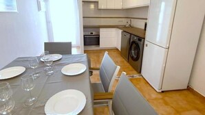 A compact kitchen with white cabinets, a washing machine, and a refrigerator. - Semi-detached house 5 bedrooms in Roses, near center with terrace and canal (Roses)