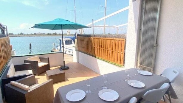 A balcony with a table set for dining, outdoor seating, and a view of the water. - Semi-detached house 5 bedrooms in Roses, near center with terrace and canal (Roses)