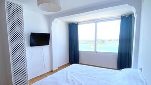 A bedroom with a bed, a TV mounted on the wall, and a window with curtains. - Semi-detached house 5 bedrooms in Roses, near center with terrace and canal (Roses)