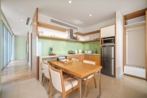 Una cucina moderna con zona pranzo, con frigorifero in acciaio inossidabile, microonde e forno integrato.