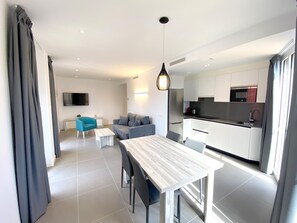 Un appartement moderne comprenant un coin repas, un salon et une cuisine.