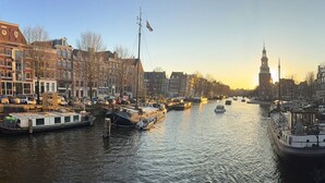 Ein Kanal mit Booten, Gebäuden und einem Turm im Hintergrund.