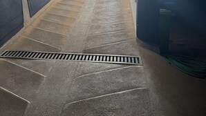 Portaat, joissa on metallinen kaide ja seinässä tuuletusaukko.