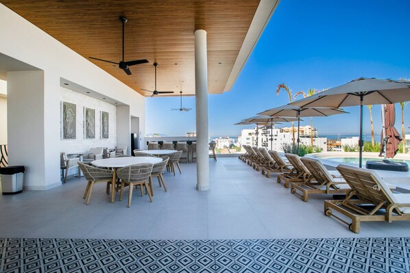 A rooftop terrace with a pool, lounge chairs, a dining area, and a view of the city. - Romantic Zone Retreat w/ Rooftop Pool + Epic Views (Puerto Vallarta)