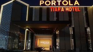 The exterior of Portola Tiara Hotel with a prominent entrance and illuminated signage.