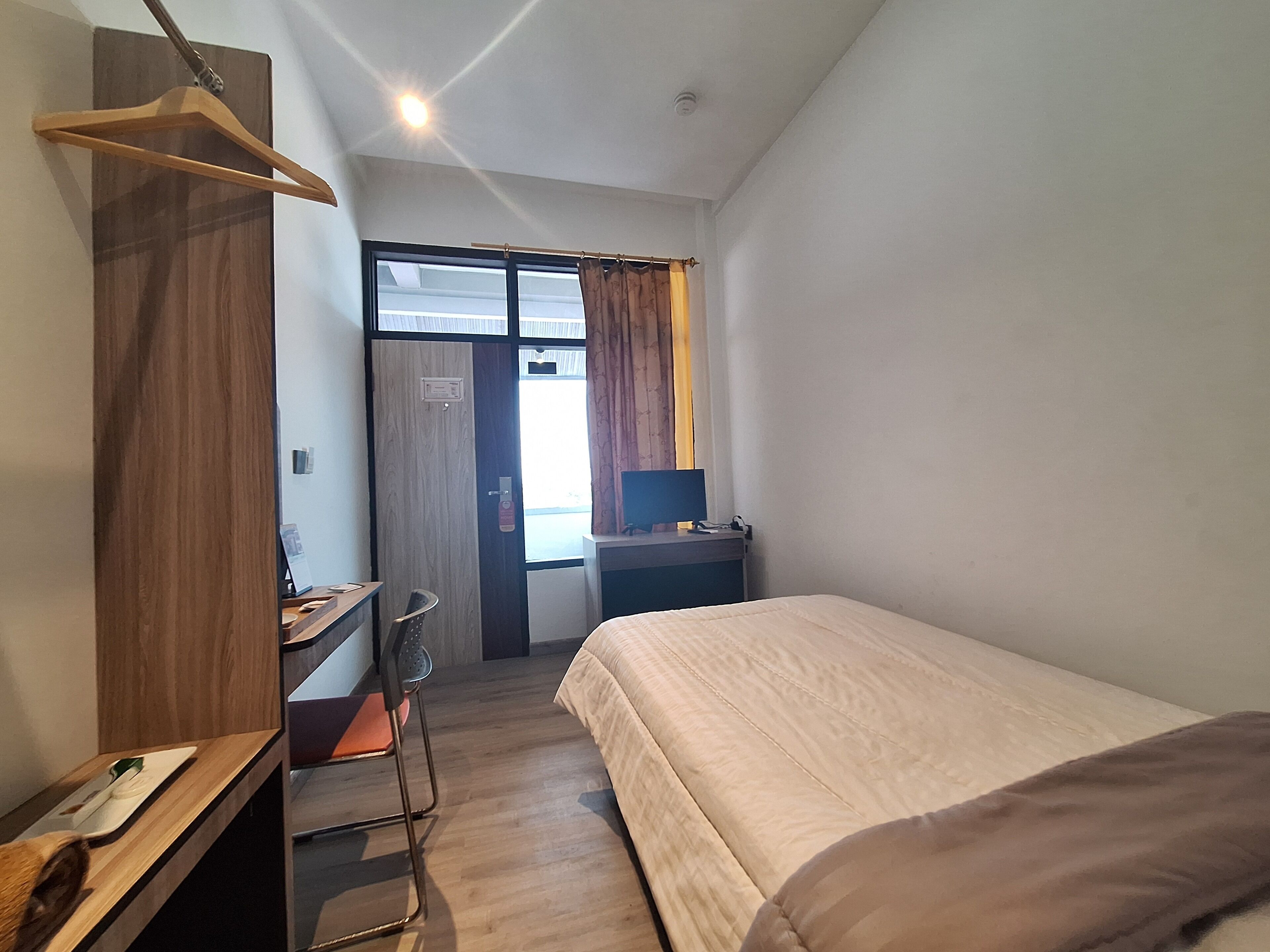 A small, clean room with a bed, a desk, a chair, and a wardrobe.