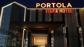 Η εξωτερική όψη του ξενοδοχείου Portola Tiara, με φωτεινές επιγραφές και διακοσμητικά αρχιτεκτονικά στοιχεία.