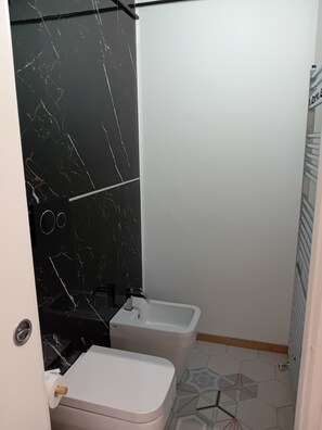 Een douche, een haardroger, een bidet, handdoeken