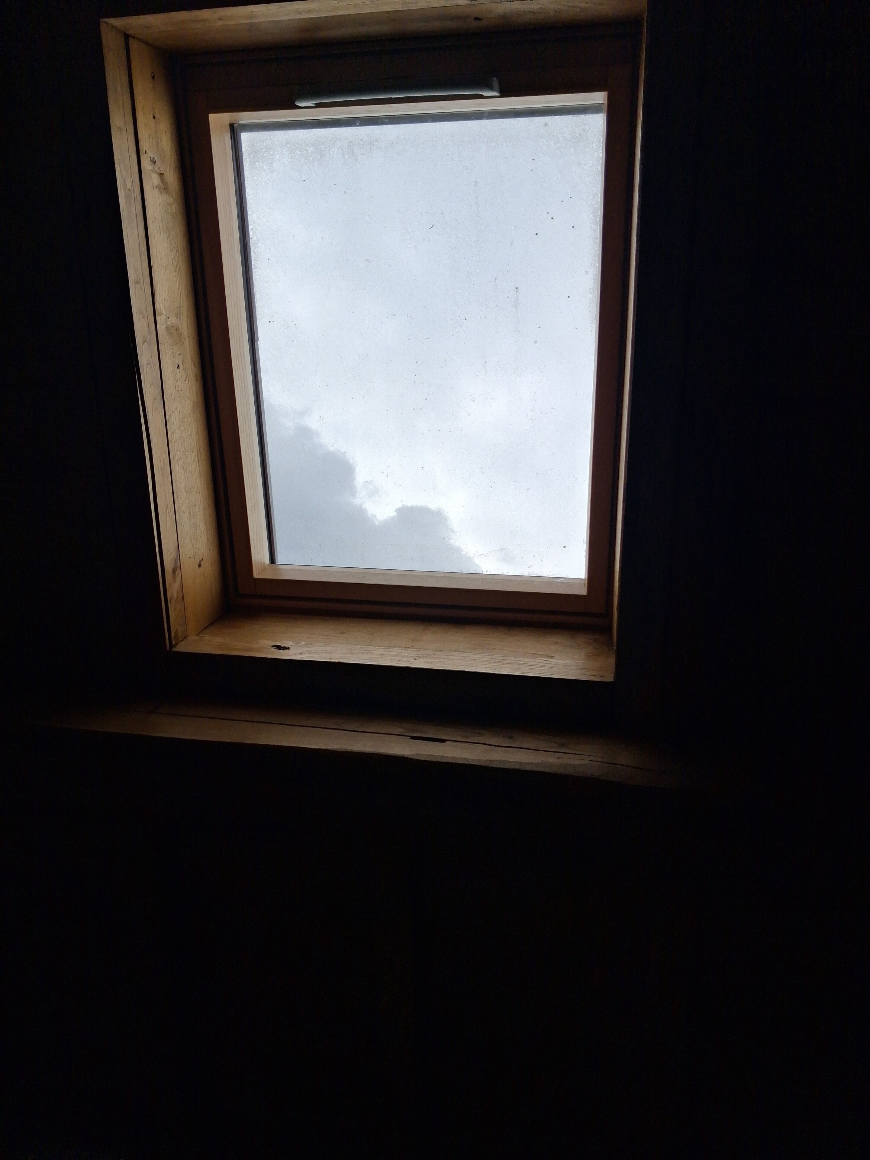 A skylight window with a view of the sky.