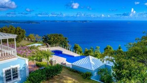 Una proprietà residenziale con piscina, patio coperto e vista sull'oceano.