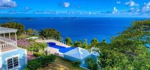 Une propriété résidentielle dotée d’une piscine, d’un patio couvert et offrant une vue sur l’océan.