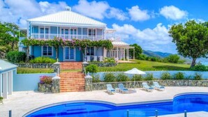 Un'ampia casa con piscina, giardino e vista sul mare.