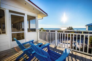 A wooden deck with blue chairs and a white railing overlooking a beach. - North Cape, gulf front, private pool and boardwalk! Pets considered (Port St Joe)