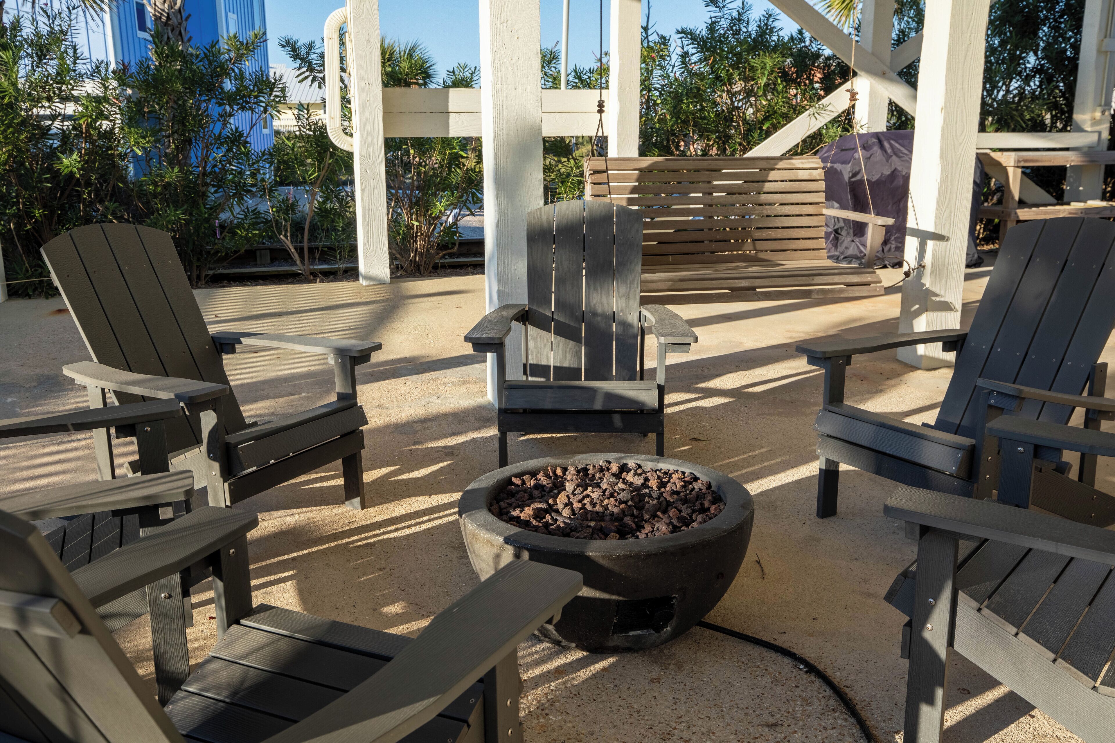 A patio area with Adirondack chairs and a fire pit.