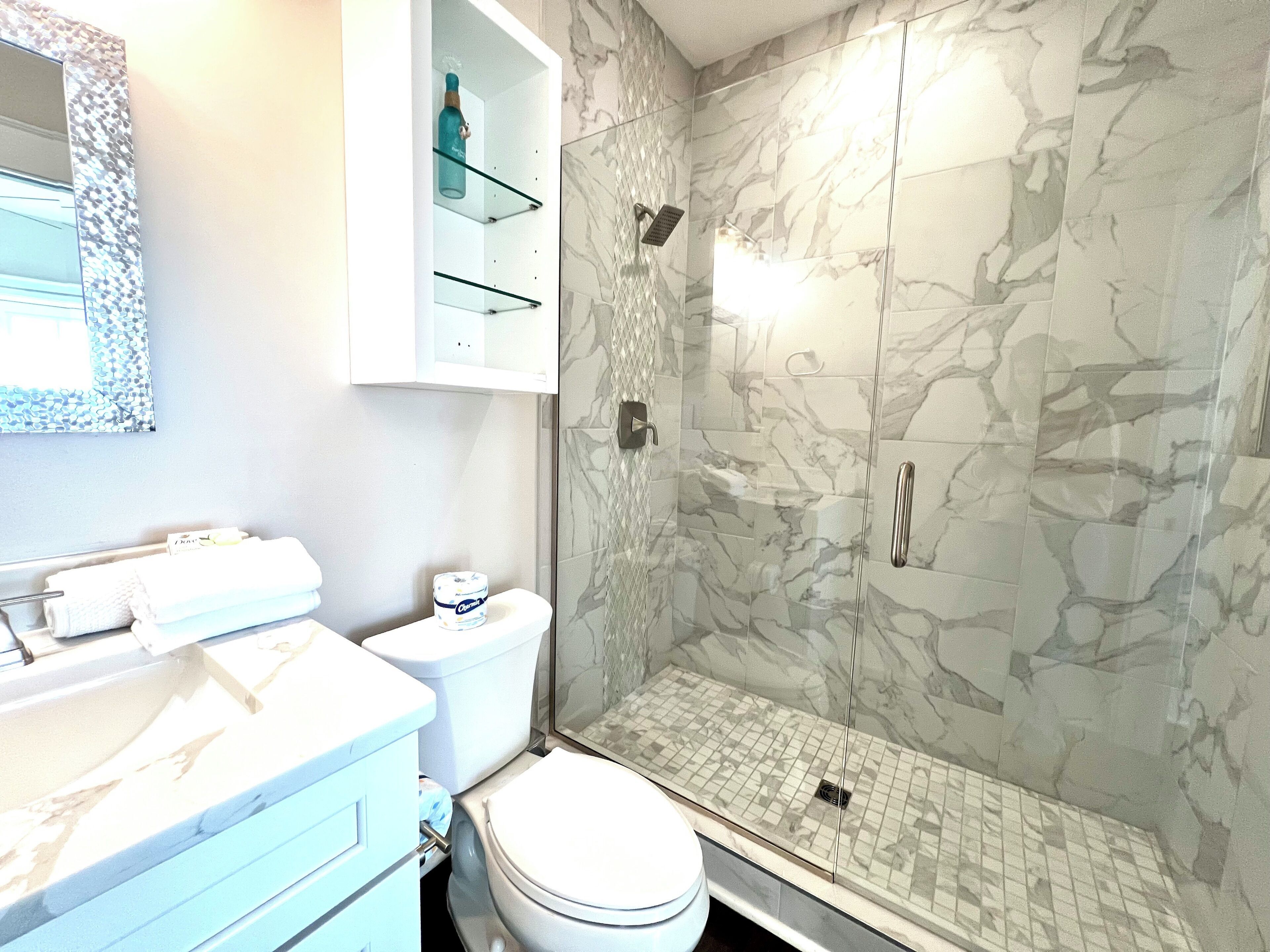 A bathroom with a toilet, sink, and shower.