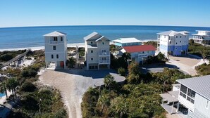Ein Küstenhotel mit mehreren Gebäuden, einem Zugang zur Strandpromenade und Blick auf den Ozean.