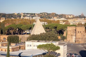 A cityscape with a prominent pyramid structure, a castle-like building, and a domed building in the distance. - Rental in Rome Pyramid View Apartment (Rome)