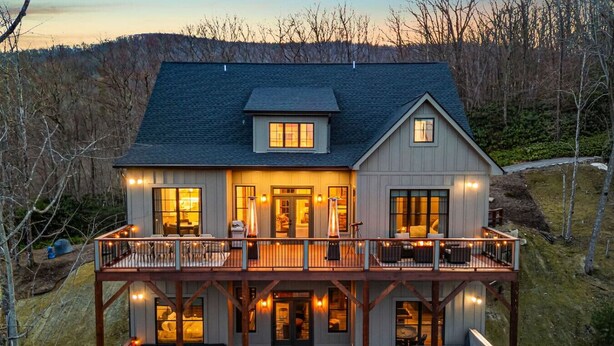 Une maison à deux étages dotée d’un balcon, d’un jacuzzi et d’une terrasse.