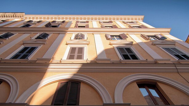A multi-story building with classical architecture, featuring arched windows and a symmetrical facade. - Rental in Rome Principe Amedeo Apartment (Rome)