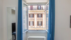 A room with a window overlooking a building with balconies and shutters. - Rental in Rome Principe Amedeo Apartment (Rome)