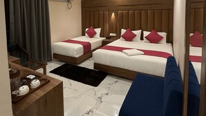 Habitación de hotel con dos camas, un ventilador de techo, una mesita de café y un espejo grande.