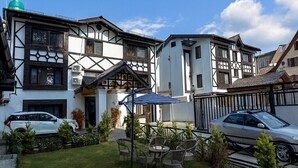 Un edificio de estilo europeo tradicional con un césped cuidado y zona de estar al aire libre.