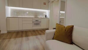 A modern kitchen with built-in appliances and a light-colored countertop. - Rossio Garden Suites (Lisbon)