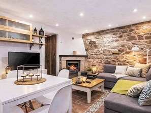 A cozy living room with a stone wall, fireplace, and modern furniture. - Jacuzzi, Kamin, Grill und spektakuläre Aussicht by Interhome (Las Ventas)