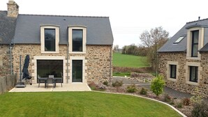 A stone house with a covered patio, a lawn, and a view of the countryside. - House Raguenez 4.5 km from the sea - Near Paimpol (Pleumeur-Gautier)