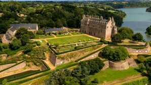 A castle with a large courtyard, surrounded by lush greenery and a body of water. - House Raguenez 4.5 km from the sea - Near Paimpol (Pleumeur-Gautier)