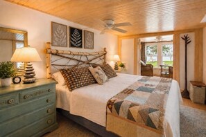 A bedroom with a bed, a dresser, a mirror, and a ceiling fan. - Lakefront and Woodland Trails-Easy Access To All Things Northern Michigan (Levering)