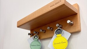 A wooden key holder with two key tags labeled "Positano Room" and "Sorrento Room". - Alla Scoperta di Napoli (Naples)