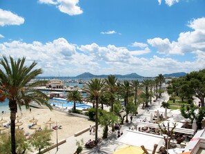 Ein Küstenresort mit Strand, Palmen und einem Yachthafen.