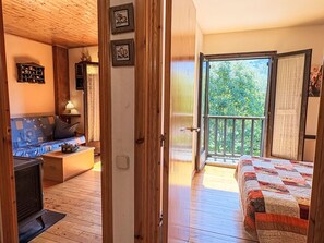 Een houten interieur met een bed, een bank en een kleine tafel.