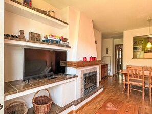 A living room with a fireplace, television, and wooden flooring. - Wohnung mit Garten Isard 4 Vall de Boí by Interhome (Caldes de Boi)