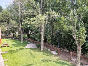 A well-maintained garden with a wooden fence, picnic tables, and a stone pathway. - Wohnung mit Garten Isard 4 Vall de Boí by Interhome (Caldes de Boi)