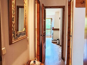 A hallway with wooden doors, a mirror, and a radiator. - Wohnung mit Garten Isard 4 Vall de Boí by Interhome (Caldes de Boi)