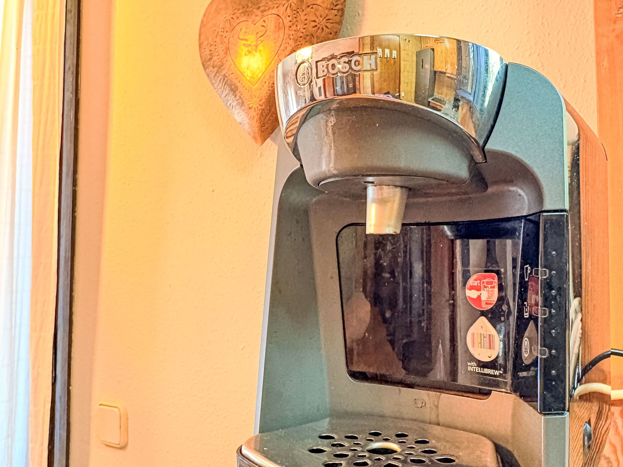 Une machine à café avec le logo Bosch, un réservoir d’eau et un panneau de boutons.
