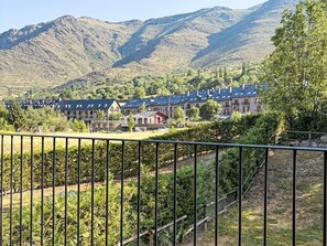 Ein Wohngebiet mit Häusern, einem Weinberg und Bergen im Hintergrund.