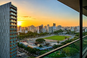 Un immeuble de grande hauteur offrant une vue sur le paysage urbain et un terrain de sport.