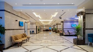 A spacious lobby with a checkered floor, seating areas, and a reception desk. - BARADIS LAND HOTEL (Makkah)