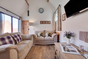 A cozy living room with a sofa, a coffee table, and a flat-screen TV mounted on the wall. - 2 Bed in Staithes (oc-wa022) (Easington)