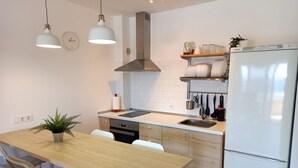 Een koelkast, een magnetron, een oven, kookgerei, borden en bestek