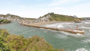 A coastal town with a beach, a breakwater, and houses on a hillside. - 3 Bed in Looe (oc-l30005) (Looe)