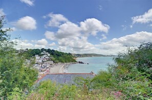 Eine Küstenstadt mit Strand, Häusern und blauem Himmel.