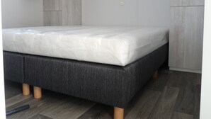 Een kamer met een bed, een kledingkast en een raam met gordijnen.
