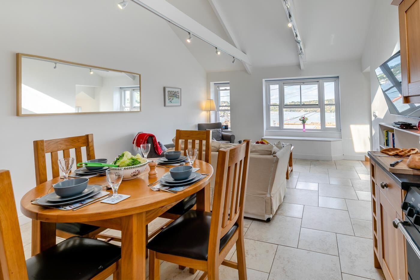 Una cocina moderna con comedor, ventanas amplias y vistas al exterior.